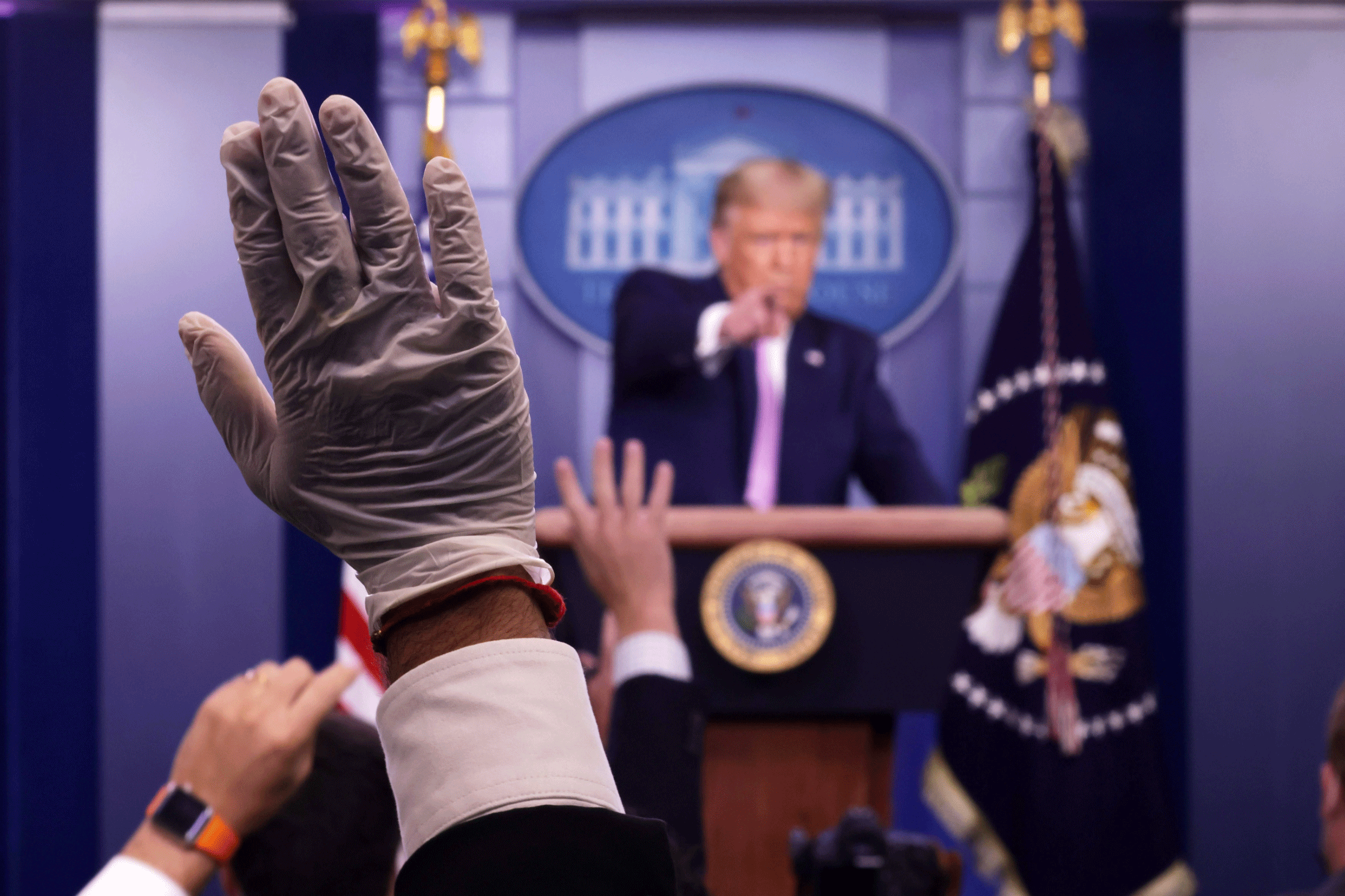 مراسل صحفي يرتدي قفازاً يطلب طرح سؤال على الرئيس الأميركي دونالد ترمب في البيت الأبيض