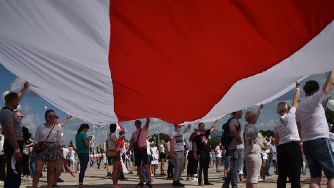 محتجون معارضون في مينسك يرفعون العلم القديم لبيلاروسيا باللونين الأحمر والأبيض 