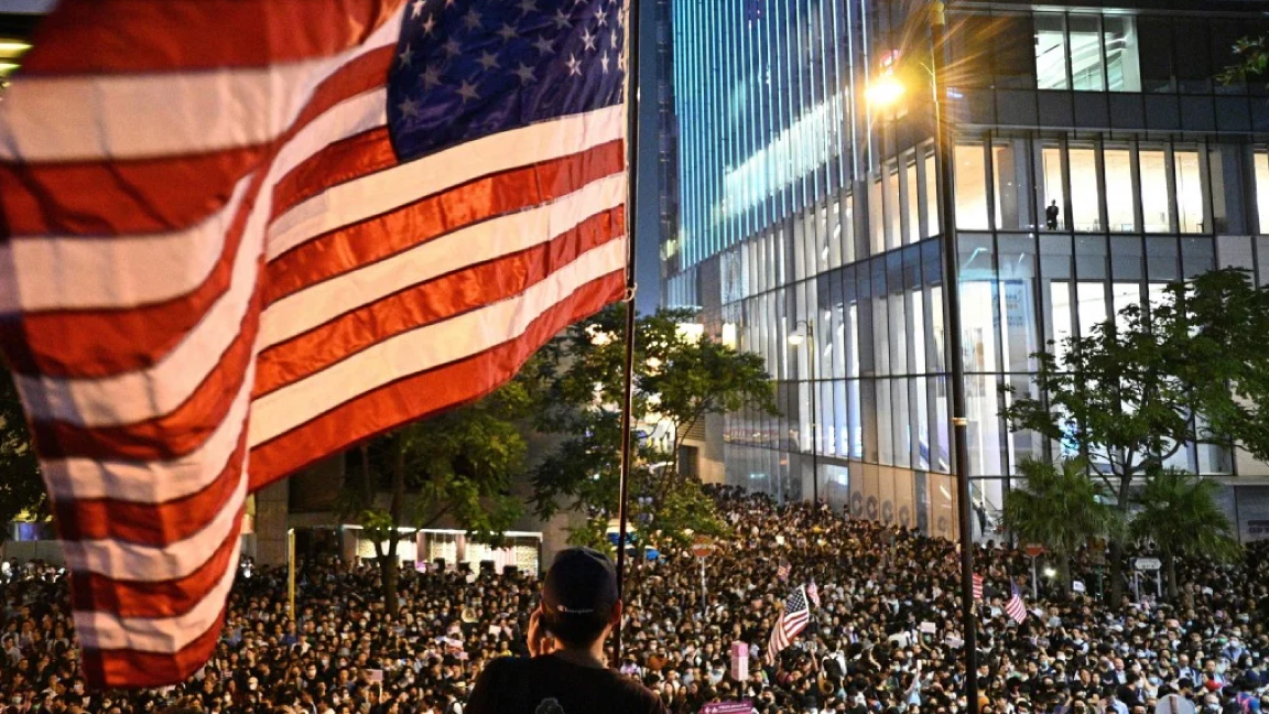 متظاهر في هونغ كونغ يرفع العلم الأميركي في إحدى التظاهرات ضد الصين في 2019