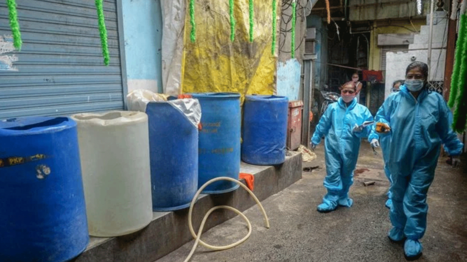 عاملون صحيون يسيرون داخل الأحياء الفقيرة في مومباي لإجراء فحوص فيروس كورونا، 24 أغسطس 2020