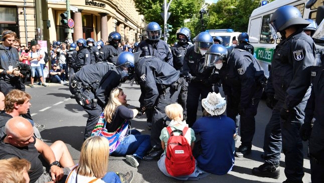 الشرطة الألمانية تحمل المتظاهرين المعتصمين في وسط الطريق في برلين