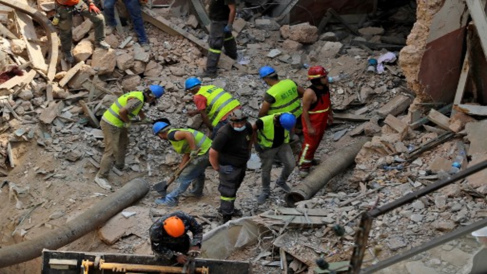 عمال الإنقاذ يستخدمون أنبوبًا لتفريغ الأنقاض من مبنى تضرر بشدة في العاصمة اللبنانية بيروت ، بحثًا عن ناجين محتملين 