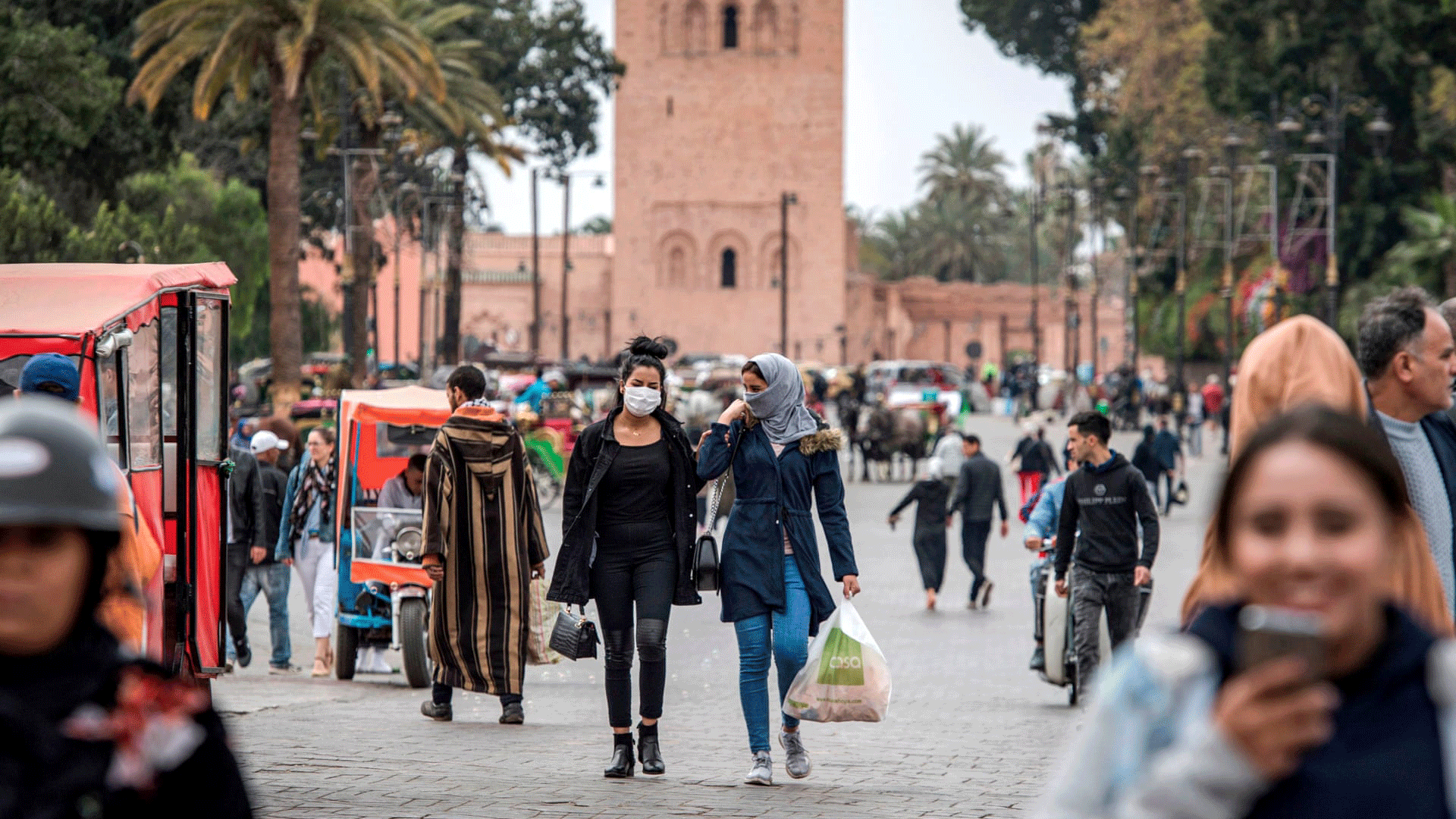 مارة يرتدون الكمامات الواقية في إحدى ساحات مراكش