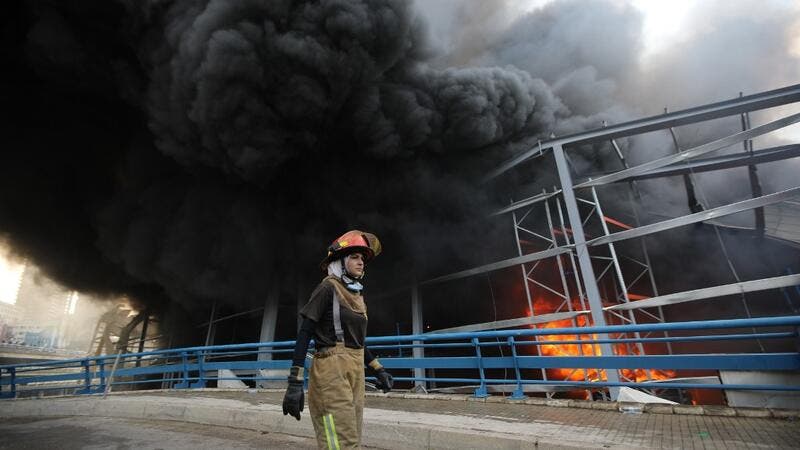 عامل إطفاء خلال محاولات السيطرة على الحريق الذي اندلع في مرفأ بيروت الخميس