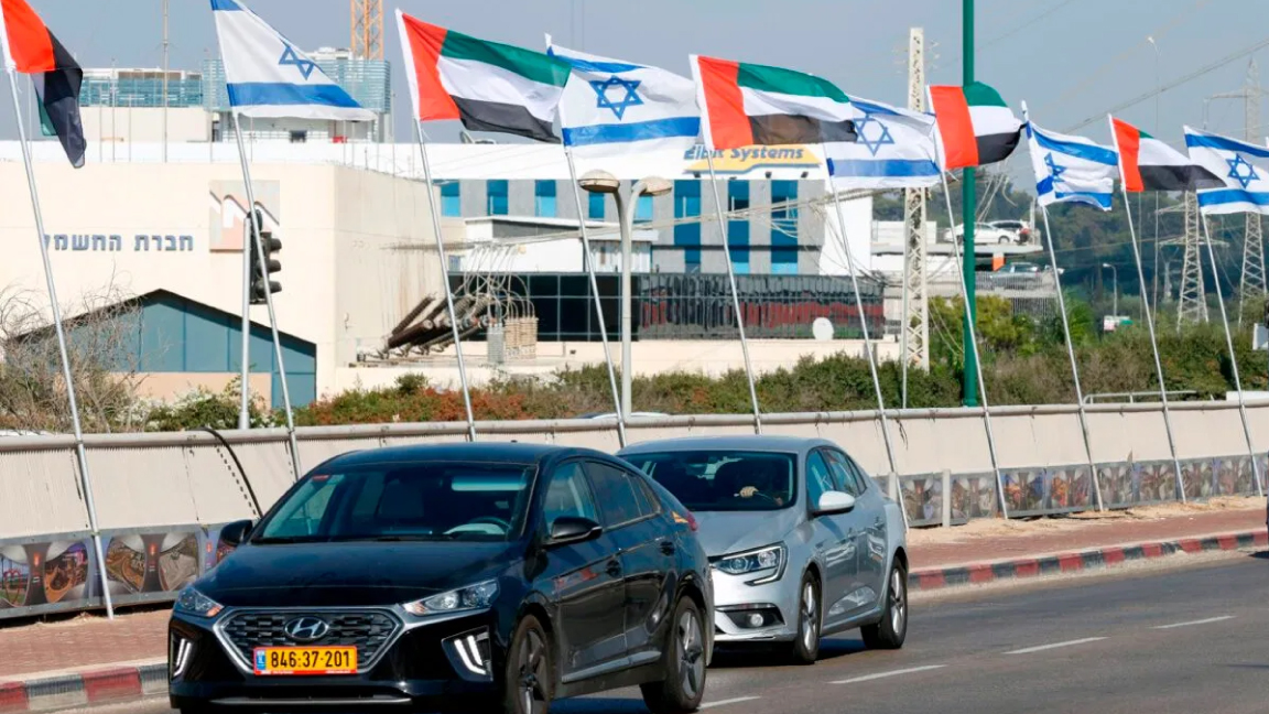 إسرائيليون يمرون تحت أعلام إماراتية وإسرائيلية رفعت في نتانيا بعد إعلان الاتفاق بين البلدين في 16 أغسطس