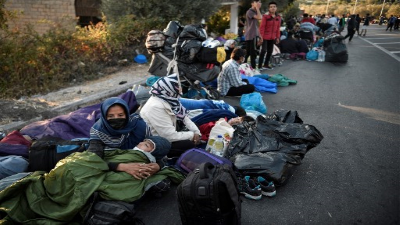 مهاجرون قضوا ليلتهم على الطريق بالقرب من ميتيليني، حيث دمر حريق أكبر مخيم للاجئين في موريا باليونان في جزيرة ليسبوس في وقت مبكر من 10 سبتمبر 2020.