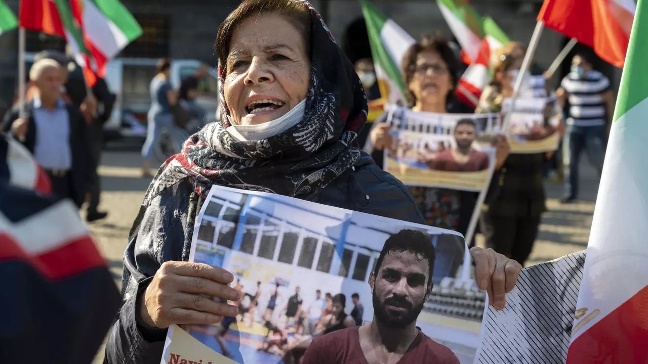 امرأة ترفع صورة المصارع الإيراني نويد أفكاري خلال تظاهرة في أمستردام بتاريخ 13 سبتمبر 2020