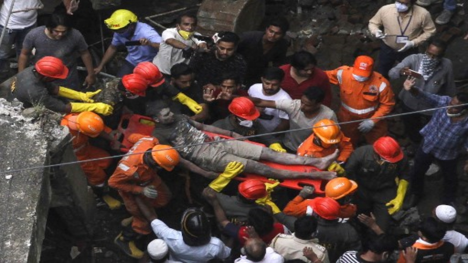 عمال الإنقاذ يحملون أحد الناجين من تحت أنقاض مبنى سكني منهار من ثلاثة طوابق في بهيواندي في 21 سبتمبر 2020
