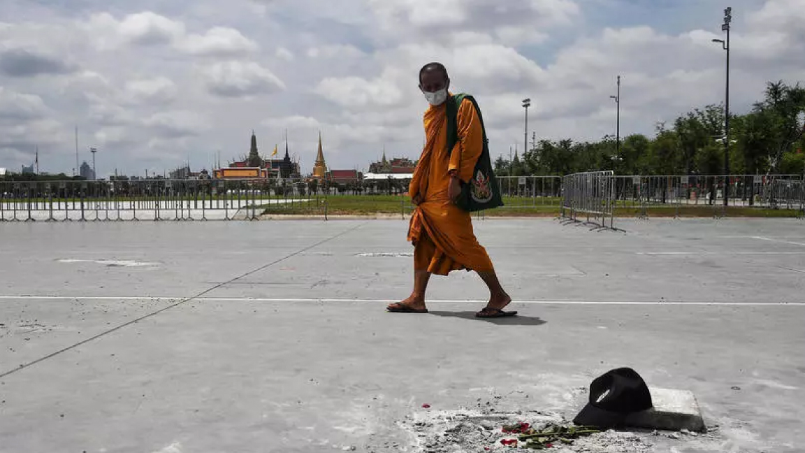 راهب بوذي في ميدان سانام لوانغ أمام القصر الملكي ببانكوك الإثنين حيث يحتج المحتجون عادة