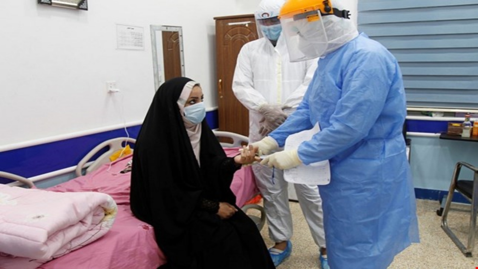 طبيب عراقي يجري فحص الكورونا لعراقية 