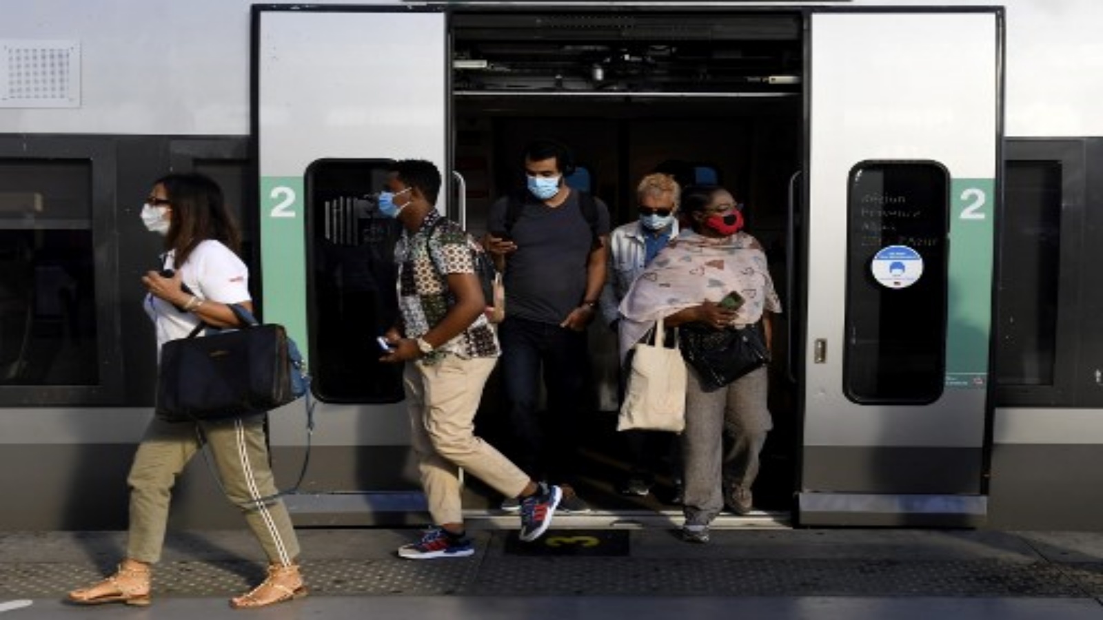 ركاب يرتدون أقنعة الوجه ينزلون من قطار في محطة سانت تشارلز في مرسيليا جنوب شرق فرنسا في 21 سبتمبر 2020