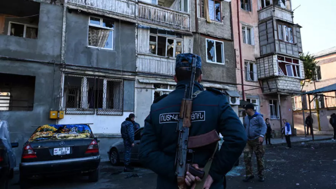 شرطي أمام مبنى سكني تضرر بالقصف في ستيباناكيرت السبت