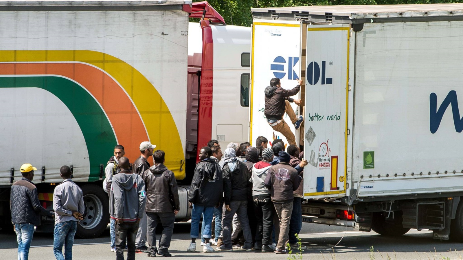 مهاجحرون غير شرعيين يستقلون شاحنة بالقرب من كاليه بفرنسا للتوجه إلى إنجلترا. أ ف ب