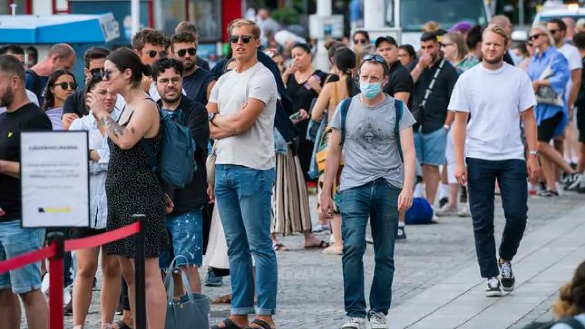 سويديون ينتظرون لركوب عبارة في سترانفاجن بستوكهولم الإثنين، وقلة منهم ترتدي كمامة