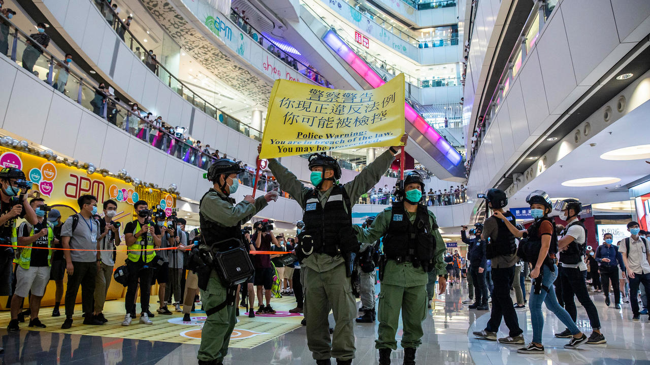 شرطة مكافحة الشغب ترفع لافتة تحذيرية خلال تظاهرة احتجاج على قانون الأمن القومي، في مركز تسوق في هونغ كونغ في 6 تموز/يوليو 2020