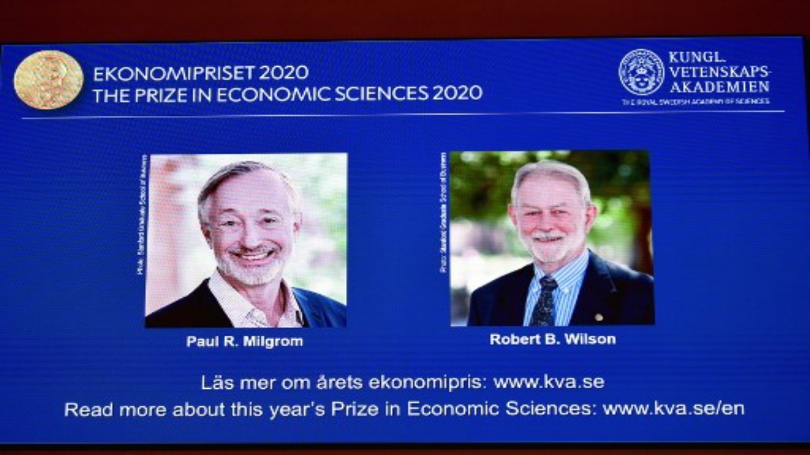 شاشة تعرض صور الاقتصاديين الأمريكيين بول ميلجروم (يسار) وروبرت ويلسون أثناء إعلان الفائزين بجائزة نوبل 2020 . أ ف ب