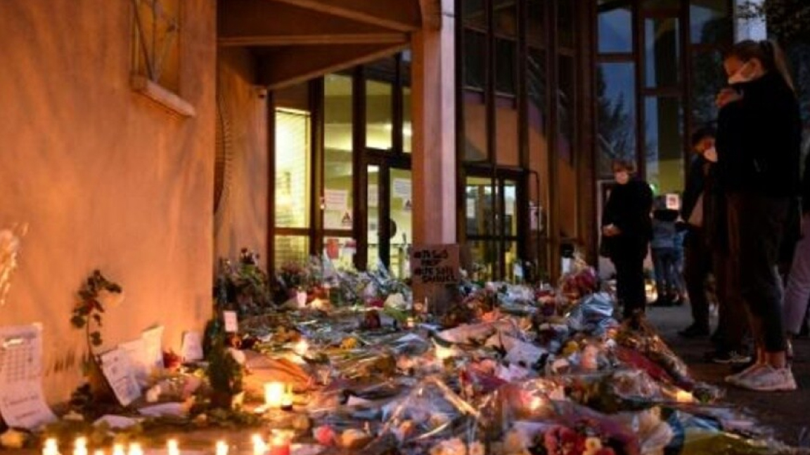 ورد وشموع السبت أمام المدرسة التي قتل فيها أستاذ التاريخ في كونفلان سانت - أونورين شمال غرب باريس