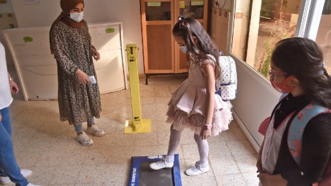 تلميذة نعقم حذاءها قبل دخولها إلى المدرسة في الجزائر الأربعاء