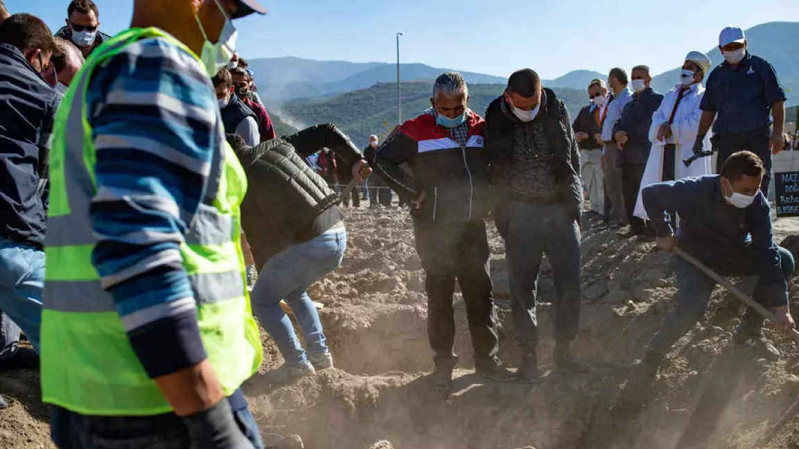 جال يحفرون قبرا لأحد ضحايا الزلزال الذي ضرب إزمير السبت