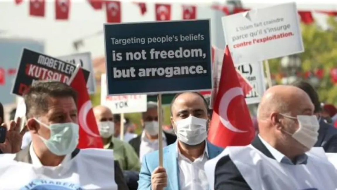 محتج تركي يحمل لافتة تندد بتصريحات الرئيس الفرنسي حول الرسوم الكاريكاتورية للنبي محمد في انقرة الثلاثاء