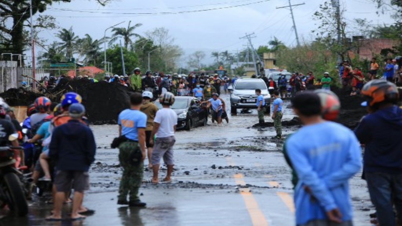سكان متجمعون على طول الطريق الذي تضرر من جراء الأمطار الغزيرة التي سببها الإعصار غوني الفائق بعد أن ضرب بلدة ماليناو ، مقاطعة ألباي ، جنوب مانيلا في 1 نوفمبر 2020.