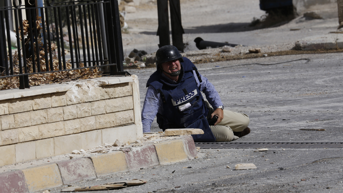 مراسل فرانس برس سامي كيتز ممدًا أرضًا بعدما أطلق عليه قناص النار في معلولا السورية في سبتمبر 2013