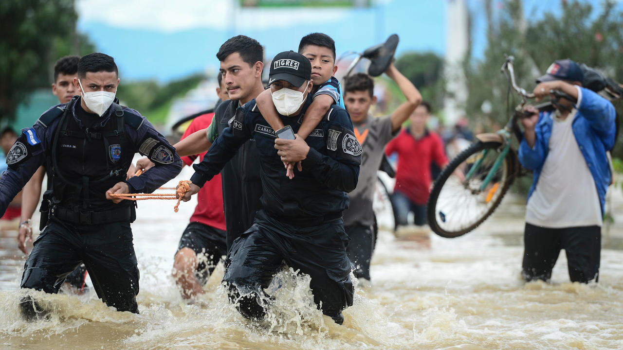 عناصر الشرطة في هندوراس يساعدون في عمليات إجلاء الاهالي بعد فيضان نهر عقب الإعصار إيتا، في إل بروغريسو على بعد 260 كلم شمال تيغوسيغالبا، في 5 تشرين الثاني/نوفمبر 2020