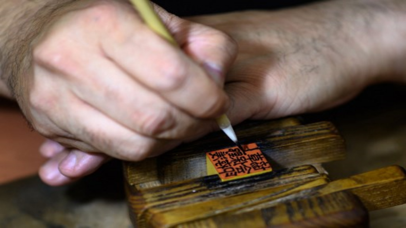  صانع ختم الحبر التقليدي تاكاهيرو ماكينو 44 عامًا وهو يكتب شخصيات على هانكو في استوديو في طوكيو.