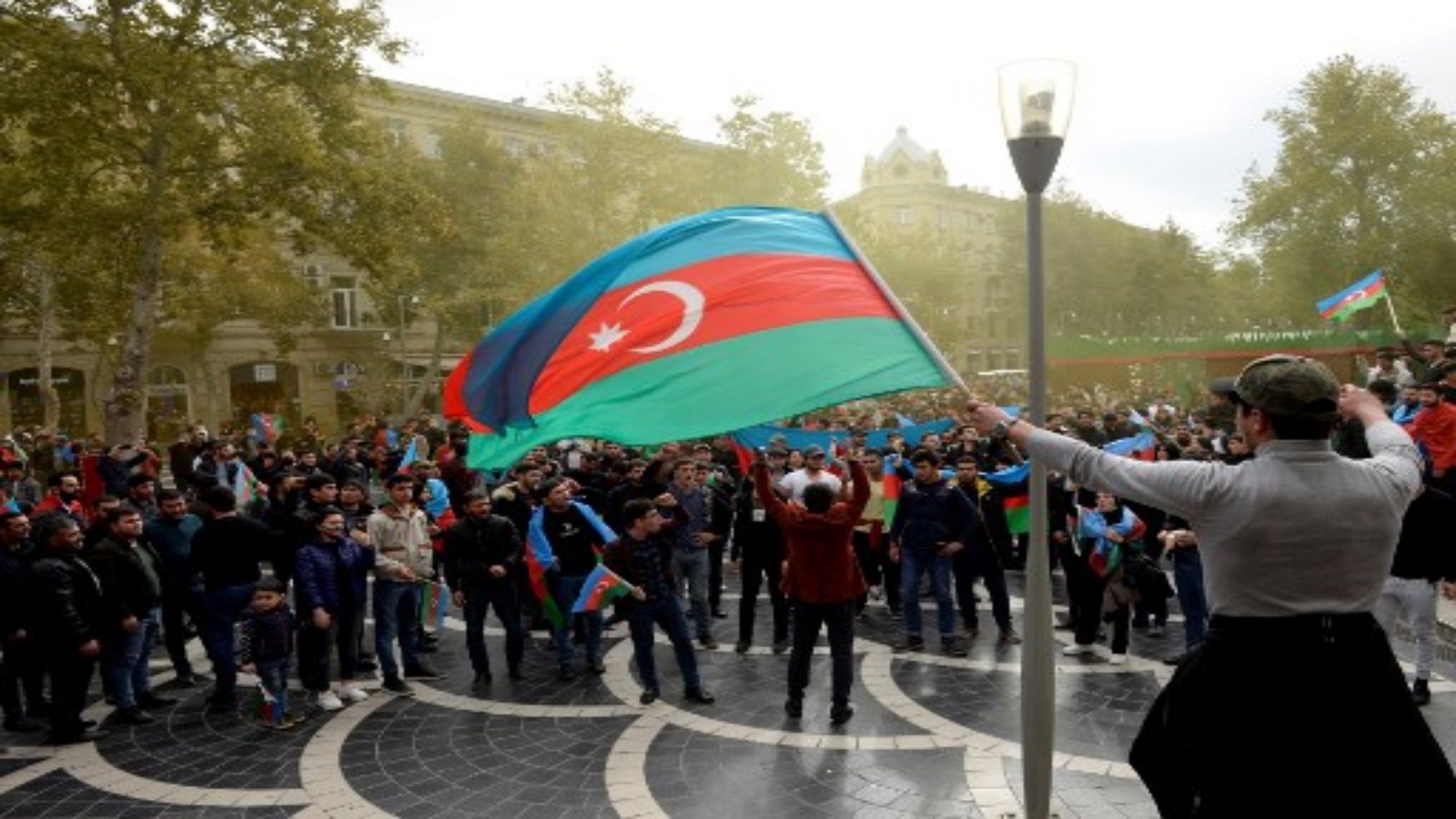 الأذربيجانيون يرفعون علمهم الوطني أثناء احتفالهم في شوارع العاصمة باكو في 10 نوفمبر 2020 ، بعد أن وافقت أرمينيا وأذربيجان على وقف إطلاق النار بعد سلسلة من الانتصارات الأذرية في القتال على منطقة ناغورنو كاراباخ المتنازع عليها