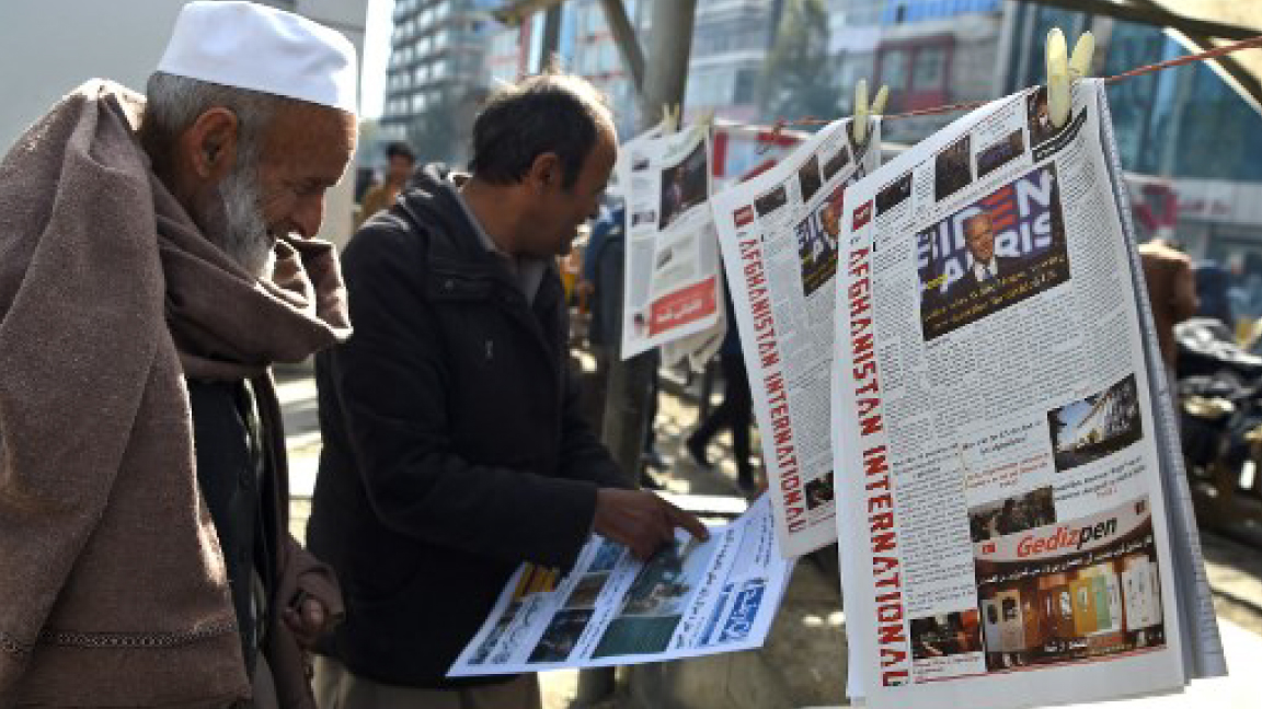 أفغاني يقرأ أنباء فوز الديمقراطي جو بادن بالرئاسة الأميركية أمام أحد أكشاك الصحف في كابول الأحد