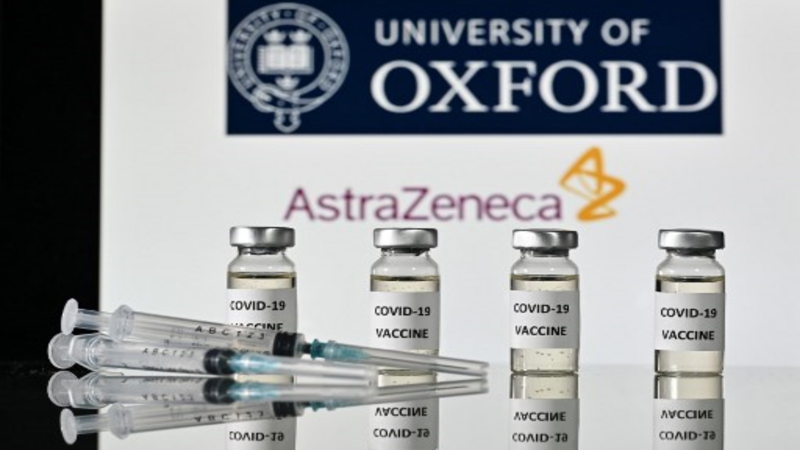  صورة توضيحية قوارير بها ملصقات لقاح Covid-19 مرفقة ومحاقن ، مع شعار جامعة أكسفورد وشريكتها شركة الأدوية البريطانية AstraZeneca ، في 17 نوفمبر 2020