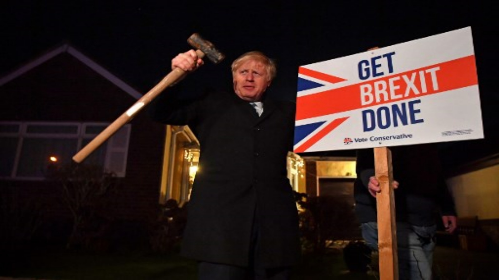صورة تم التقاطها في 11 ديسمبر 2019 يقف رئيس الوزراء البريطاني وزعيم حزب المحافظين بوريس جونسون بعد دق لافتة 