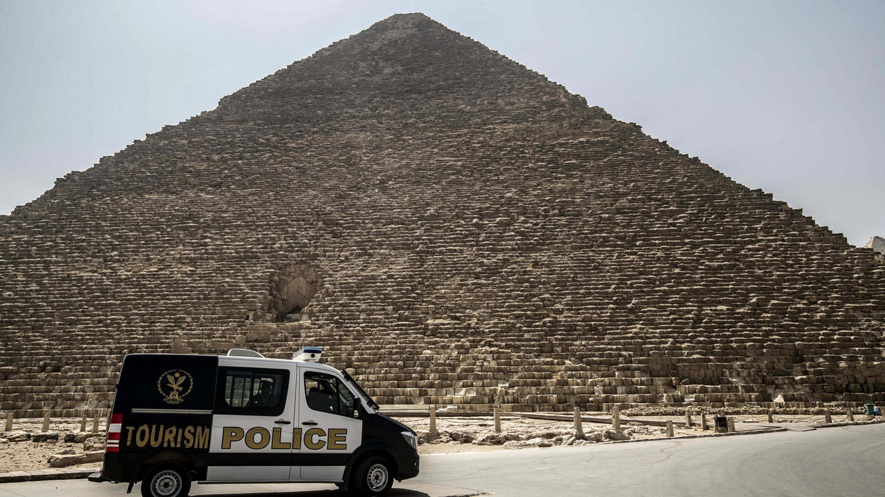 سيارة شرطة مصرية تقوم بدورية أمنية قرب اهرامات الجيزة في جنوب غرب القاهرة في 25 آذار/مارس 2020