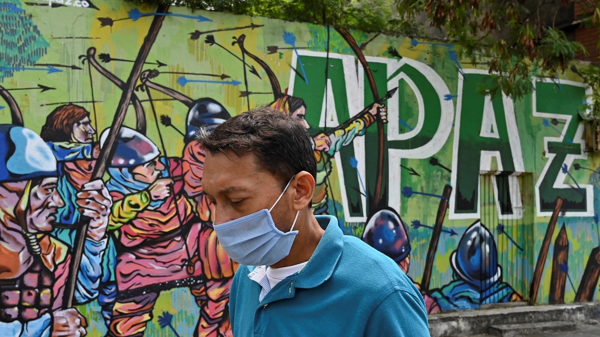 أحد المارة أمام لوحة غرافيتي في العاصمة الكولومبية