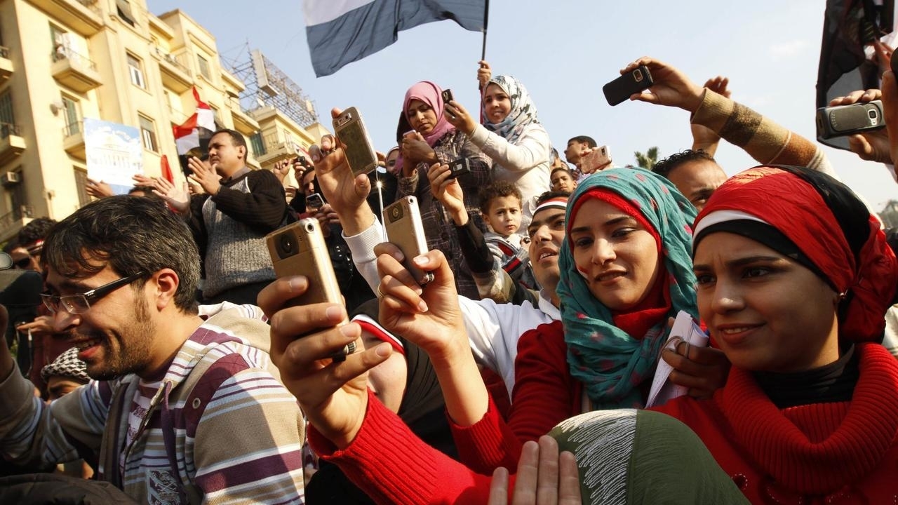 مصريون يوثقون بهواتفهم الاحتفالات في ساحة التحرير في القاهرة يوم 12 فبراير 2011