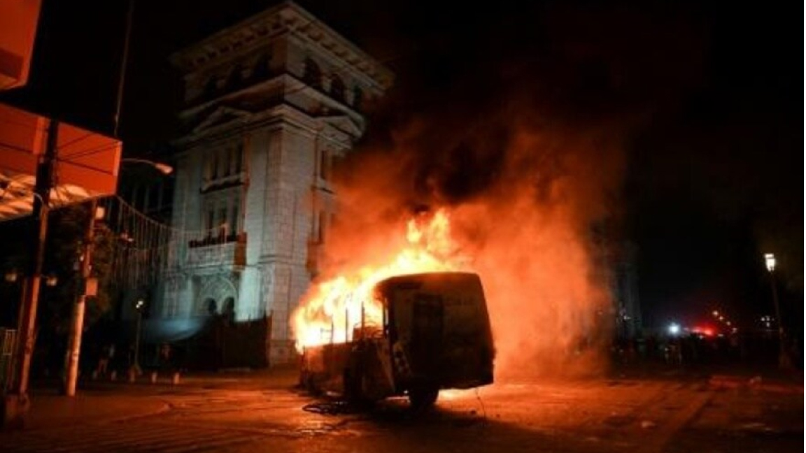 حافلة أضرم متظاهرون يطالبون باستقالة رئيس غواتيمالا، النار فيها في ساحة العاصمة فجر الأحد