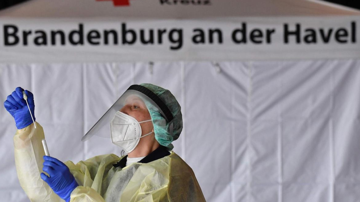 ممرضة تتفحص أداة المسحة الأنفية لاختبار كورونا في أحد مستشفيات برلين