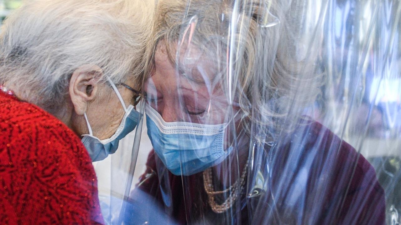نزيلة دار لرعاية المسنين قرب البندقية تحتضن ابنتها عبر ستار بلاستيكي في 11 تشرين الثاني/نوفمبر 2020