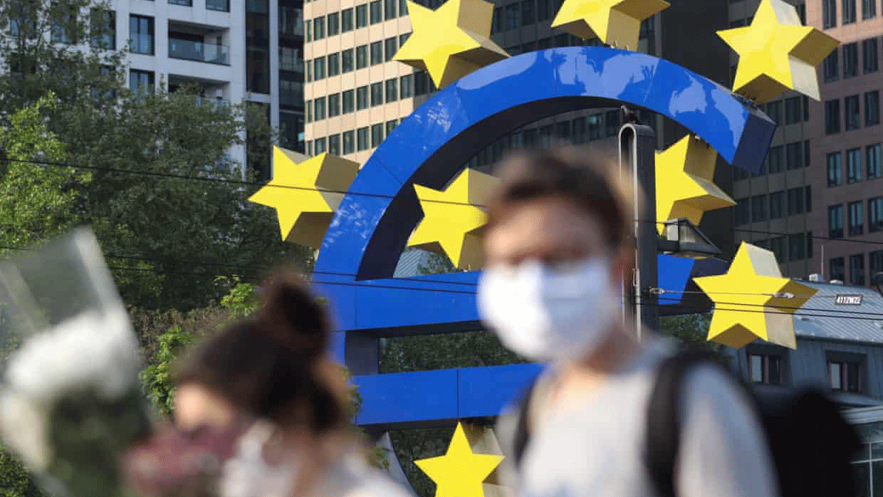 مارة يرتدون كمامات واقية أمام مقر البنك المركزي الأوروبي في فرانكفورت