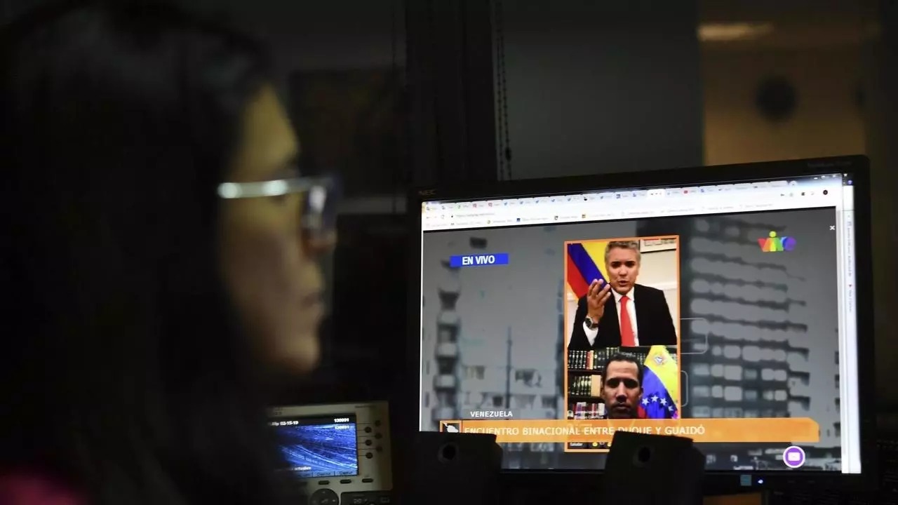صحافية تتابع لقاء على الانترنت بين الرئيس الكولومبي ايفان دوكي وزعيم المعارضة الفنزويلية نيكولاس مادورو، في كراكاس في 15 فبراير 2020
