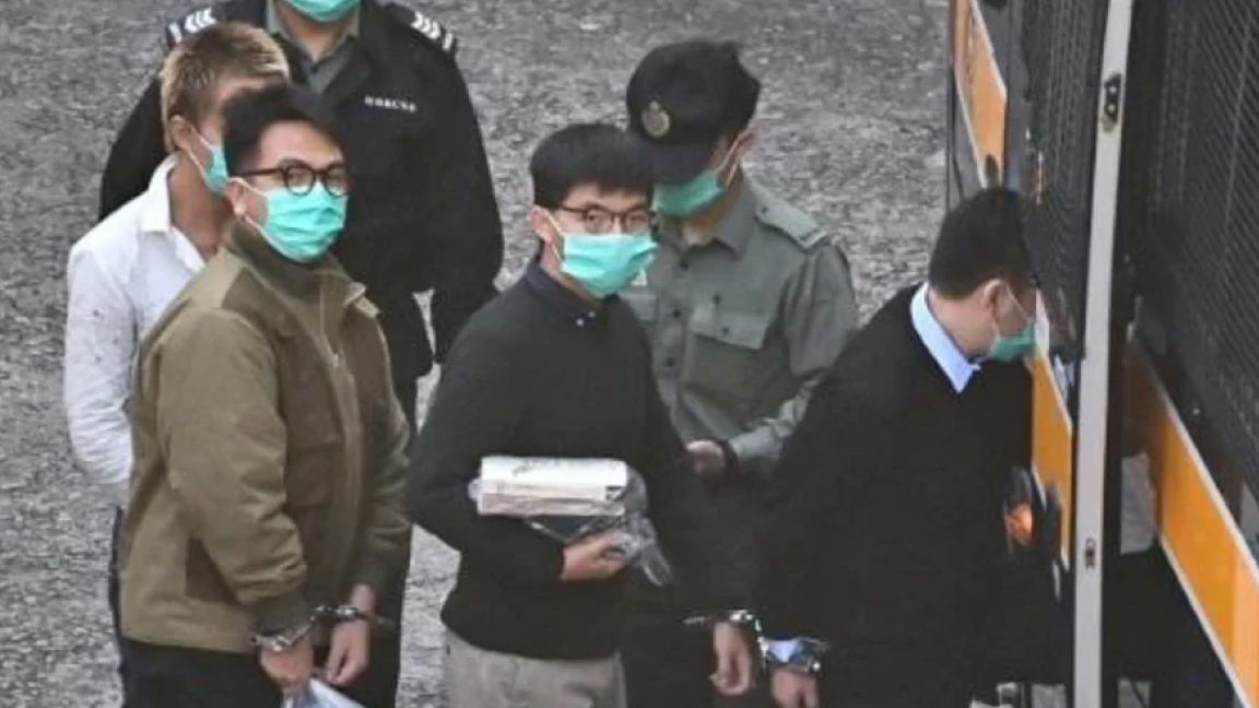 لناشطان جوشوا وونغ (وسط) وإيفان لام (يسار) يصعدان إلى آلية للشرطة في هونغ كونغ الأربعاء للتوجه إلى المحكمة للنطق بالحكم في حقهما لمشاركتهما في تظاهرة في 2019