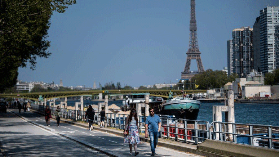 مارة على ضفاف نهر السين في العاصمة الفرنسية باريس ويدو في الخلفي برج إيفل