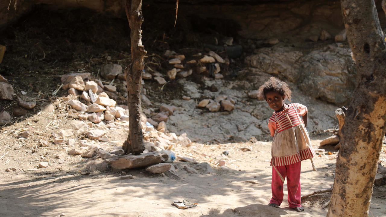 طفلة يمنية تقف أمام كهف تقيم فيه اسرتها الفقيرة غرب ضواحي تعز، ثالث أكبر مدن اليمن، في 2 كانون الأول/ديسمبر 2020
