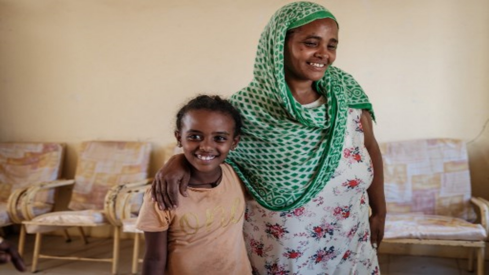 اللاجئة الإثيوبية شالوم (يسار) ، البالغة من العمر 7 سنوات ، تبتسم مع والدتها عطاش أثناء لم شملهما بعد شهر واحد من الانفصال أثناء الهروب من صراع تيغراي الإثيوبي في مركز استقبال الحدود في حمداييت ، شرق السودان ، في 8 ديسمبر ، 2020.