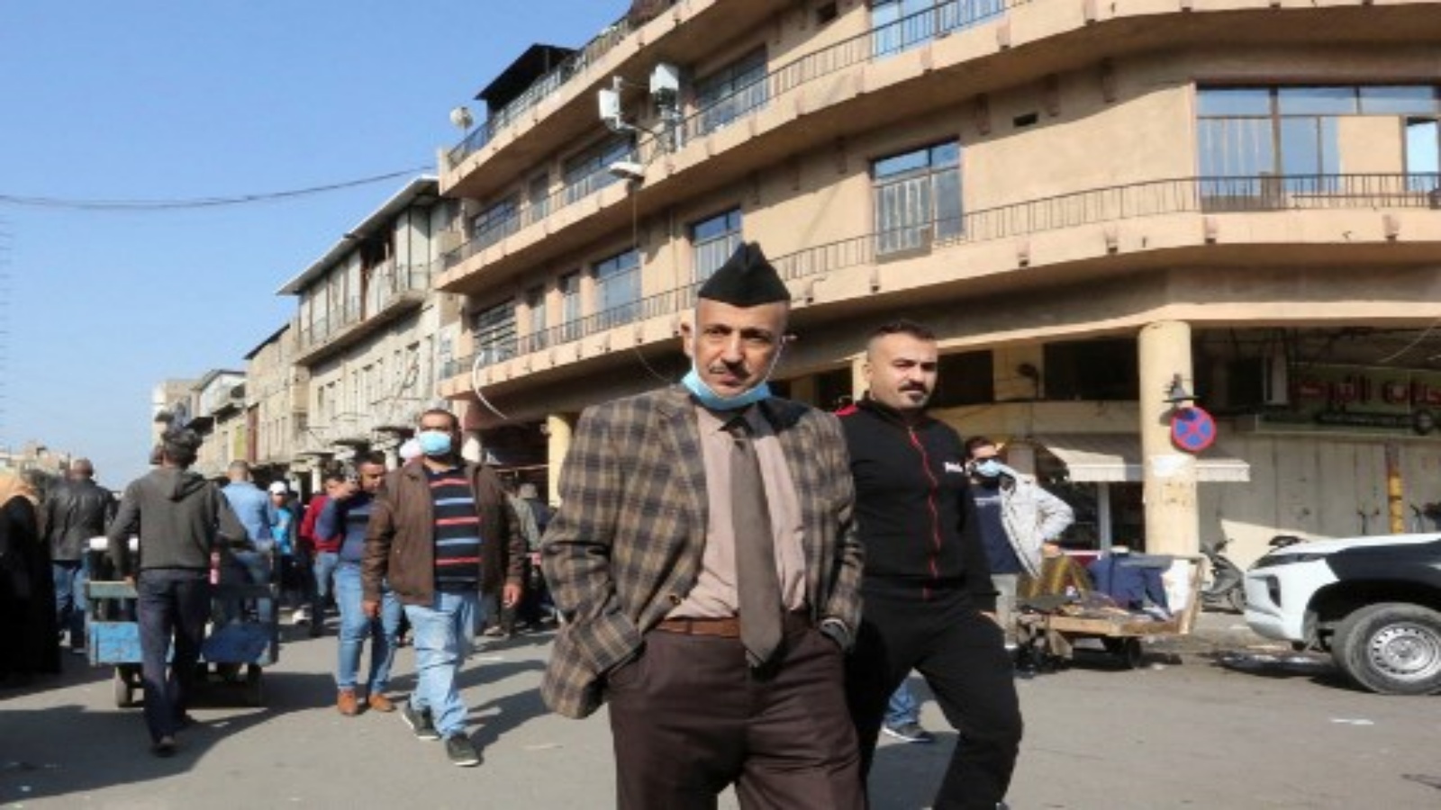 رجال عراقيون بدون أقنعة وسط مسيرة جائحة Covid-19 في العاصمة بغداد في 4 ديسمبر 2020. في حين أن الكثير من العالم يخشى Covid-19 ، توقف العراقيون في الغالب عن ارتداء أقنعة الوجه لأنهم قلقون أكثر من التأثير الاقتصادي للوباء أكثر من الفيروس نفسه