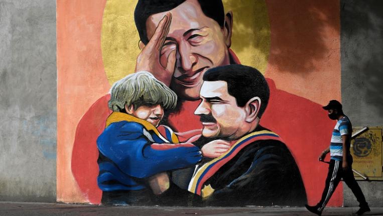 جدارية في كاراكاس تصور شافيز ومادورو الذي يظهر في الرسم وهو يحمل طفلاً. 9 ديسمبر 2020.