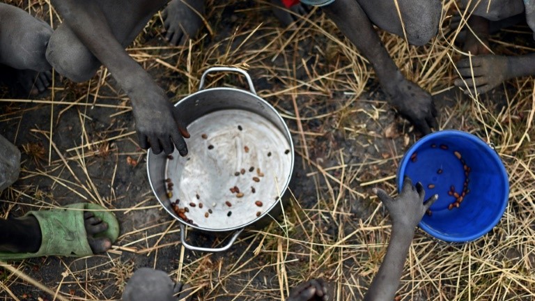 أطفال يجمعون حبوباً وقعت أرضاً من أكياس مساعدات أُلقيت من طائرات في منطقة أيود في جنوب السودان