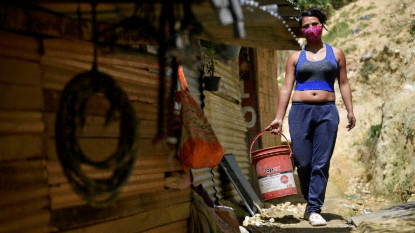 امرأة تحمل دلواً وتستعد لتحضير طعام الغداء في بوغوتا