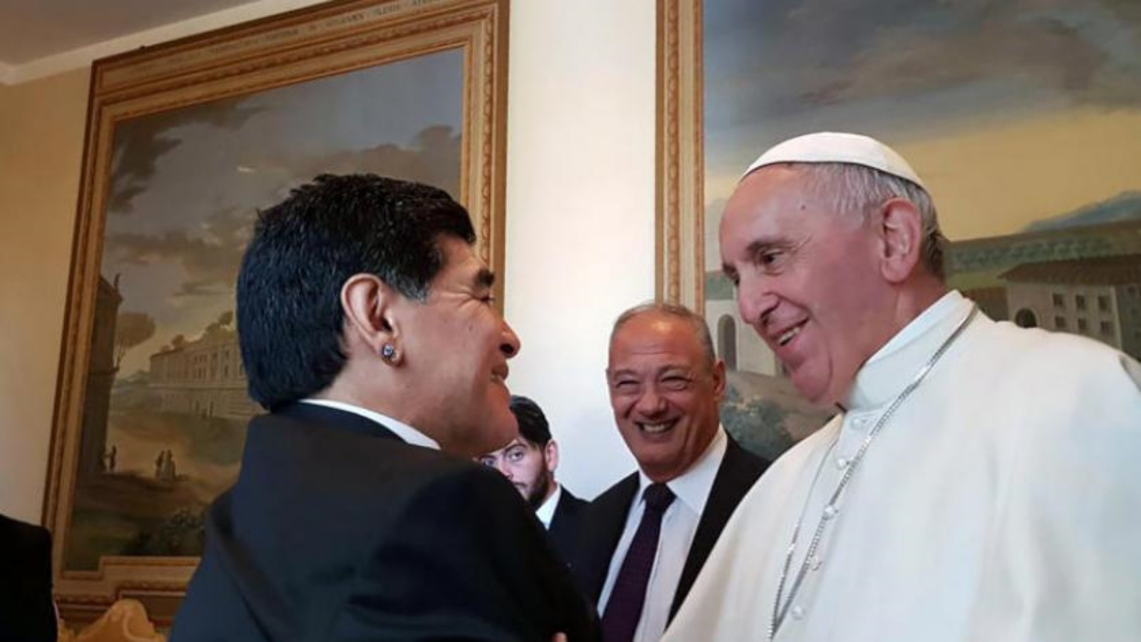 البابا فرنسيس وهو يحيي لاعب كرة القدم الأرجنتيني الراحل دييغو مارادونا خلال زيارته الفاتيكان في 12 أكتوبر 2016 (أ.ف.ب)
