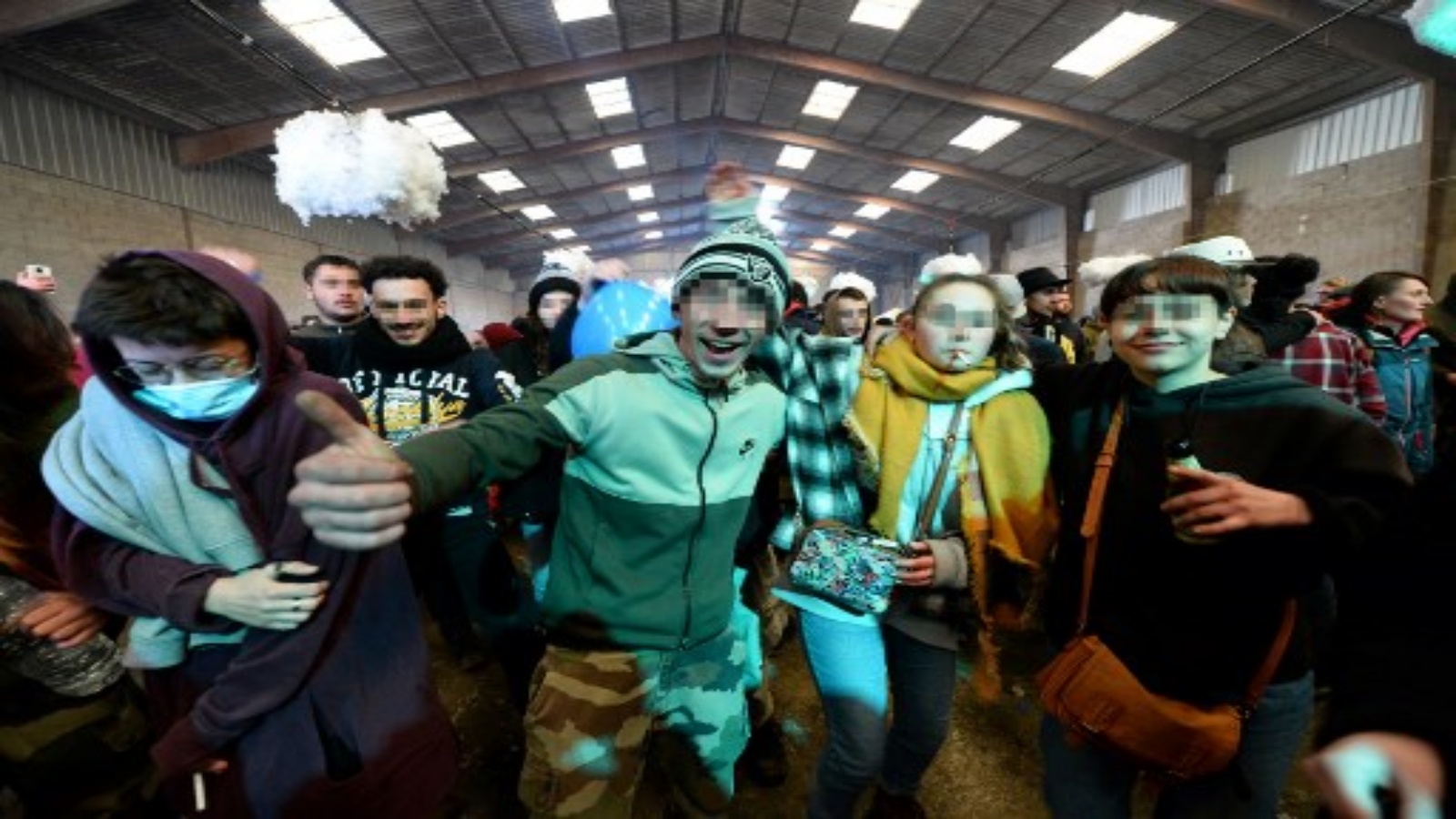 شباب يقفون أمام المصور أثناء حفلة في حظيرة مهجورة في ليورون على بعد حوالي 40 كيلومترًا (حوالي 24 ميلًا) جنوب رين ، في 1 يناير 2021